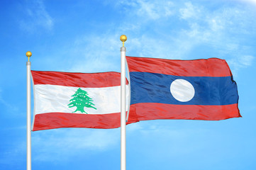 Lebanon and Laos. two flags on flagpoles and blue cloudy sky