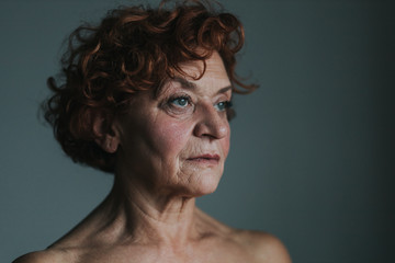 Mature woman by the window thinking about life