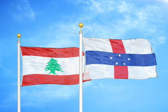 Lebanon and Netherlands Antilles two flags on flagpoles and blue cloudy sky