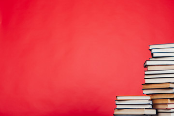 many stacks of educational books for learning the preparation for exams on a red background