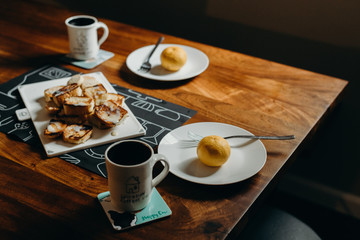 Table setting for breakfast - Plate, fork, cup and toast on the wooden table.