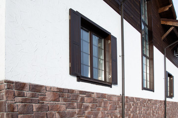 Chalet House. Windows in a large chalet cottage. Facade of a cottage in the style of a chalet.