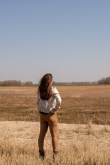 Beautiful young woman looks into the distance in nice weather