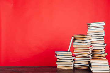 many stacks of educational books for learning the preparation for exams on a red background