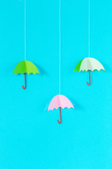 Fototapeta na wymiar blue background with an umbrella on a rope of paper