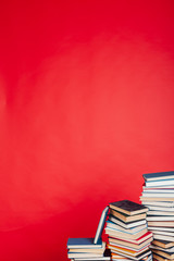 many stacks of educational books for learning the preparation for exams on a red background
