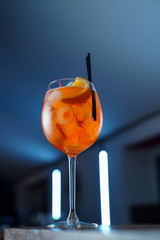 Low angle shot of bitter Aperol spritz on blue neon background