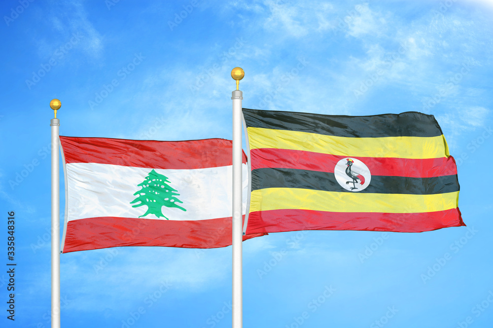 Wall mural lebanon and uganda two flags on flagpoles and blue cloudy sky