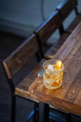 Classic old fashioned cocktail with bourbon and whiskey on wooden table in a neon light bar, top view