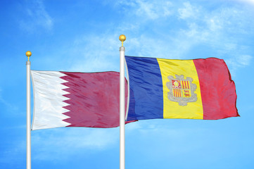 Qatar and Andorra  two flags on flagpoles and blue cloudy sky