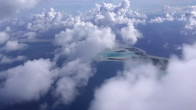 Flying though the clouds, over the atoll