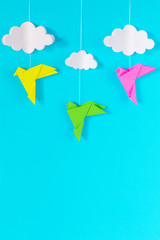 blue background with colorful birds and white clouds on a rope of paper