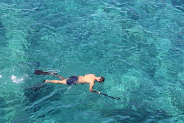 pêcheur au harpon dans une eau transparente et turquoise