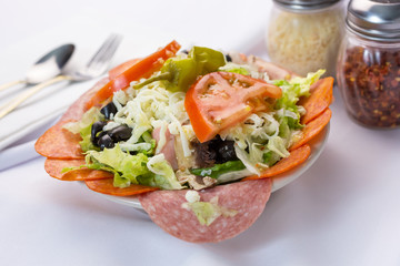 A view of a bowl of antipasto salad, in a restaurant or kitchen setting.