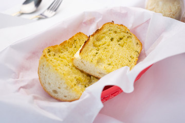 A view of a basket of garlic bread, in a restaurant or kitchen setting.