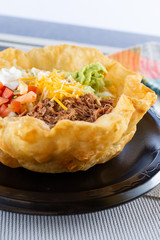 A view of a Mexican tostada taco salad, in a restaurant or kitchen setting.