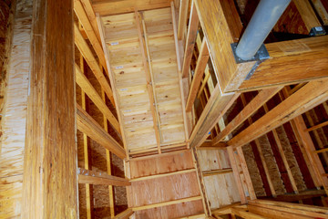 Close-up of beam built home under construction with wooden truss, post and beam framework. Timber frame house,