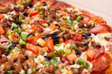 A closeup view of a deluxe topping pizza pie.