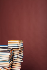 many stacks of educational books for learning the preparation for exams on a brown background