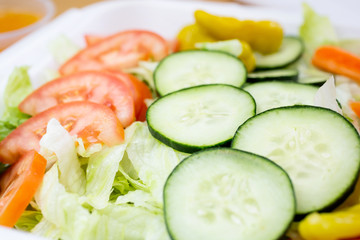 A closeup view of a common iceberg lettuce salad, in a restaurant or kitchen setting.