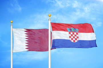 Qatar and Croatia two flags on flagpoles and blue cloudy sky