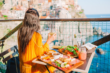 Beautiful woman on breakfast at outdoor cafe with amazing view in Cinque Terre