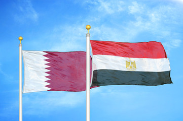 Qatar and Egypt two flags on flagpoles and blue cloudy sky