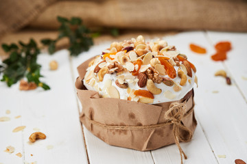 Easter cake decorated by nuts and dried fruits on white wooden background, Traditional Kulich, Paska  ready for celebration