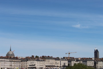 Fototapeta na wymiar Quai de la Fosse à Nantes vu depuis l'ile beaulieu avec un grand ciel bleu