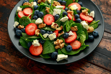 Spinach, Strawberry, blueberry salad with walnut and feta cheese. Summer healthy food