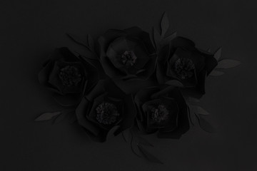 black background with flowers made of paper, top view
