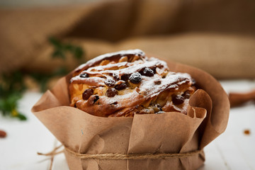 Easter cake decorated by raisins and icing sugar on white wooden background, Traditional Kulich, Paska  ready for celebration