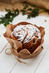 Easter cake decorated by raisins and icing sugar on white wooden background, Traditional Kulich, Paska  ready for celebration