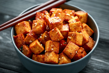 Fried Tofu in a bowl with chopstick and sesame seeds