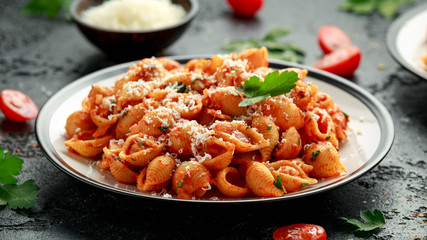 Conchiglie rigate pasta with chickpeas in tomato sauce with parmesan cheese. Healthy vegan food.