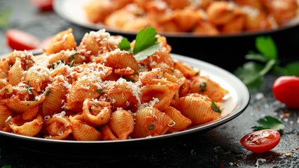 Conchiglie rigate pasta with chickpeas in tomato sauce with parmesan cheese. Healthy vegan food.
