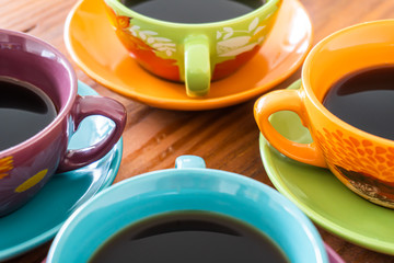 Tazas de colores de café sobre mesa de madera