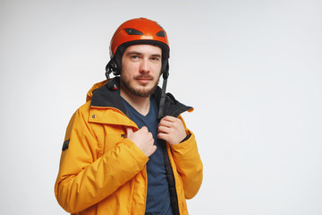 Young man in helmet is posing in studio, isolated on white background.