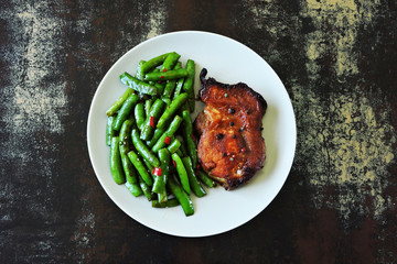 Meat steak with green beans on a plate. Keto Paleo. Pegan diet. Healthly food. Meat and vegetables. Cooking at home.