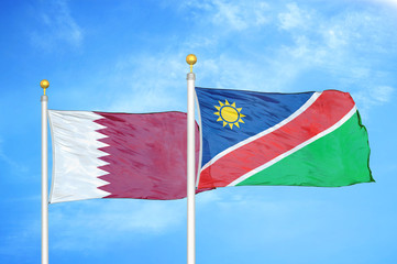 Qatar and Namibia two flags on flagpoles and blue cloudy sky