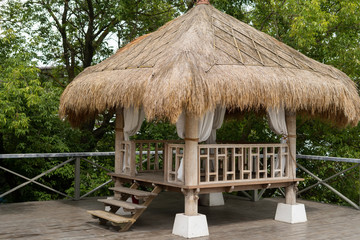 Fototapeta na wymiar Garden furniture made of natural materials, thatched roof.