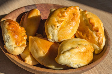 Baked cakes. Yeast baking. Pies with meat, cabbage and mushrooms. Homemade food. Slavic cuisine. Delicious pastries. Ruddy snack. Flour product. Bake in the oven. Junk food.