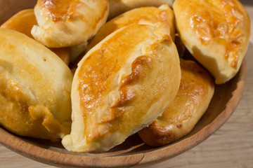 Baked cakes. Yeast baking. Pies with meat, cabbage and mushrooms. Homemade food. Slavic cuisine. Delicious pastries. Ruddy snack. Flour product. Bake in the oven. Junk food.