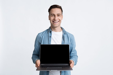 Guy laughs and shows laptop with empty screen