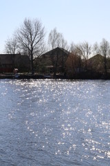 Reflection of the sun in the lake against the background of the village.