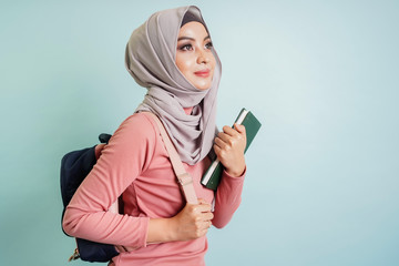Confident Asian Muslim student girl holding book , library, university, learning and education concept.