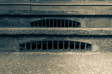 Front door staircase with opening to the sewers. Black and white picture of a front porch opening...