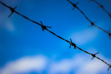 Barbed wire with the sky in the background
