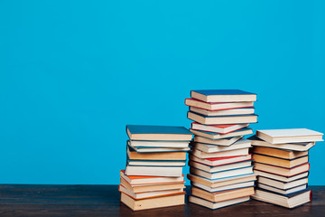 many stacks of educational books for learning preparation for college exams on a blue background