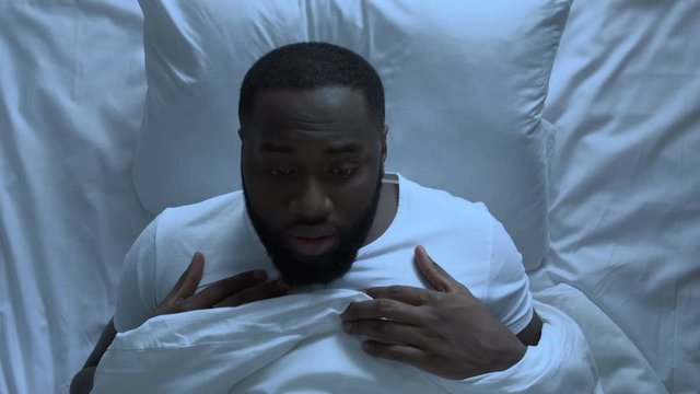 Anxious man suddenly waking up suffering from nightmare, stressful life, topview